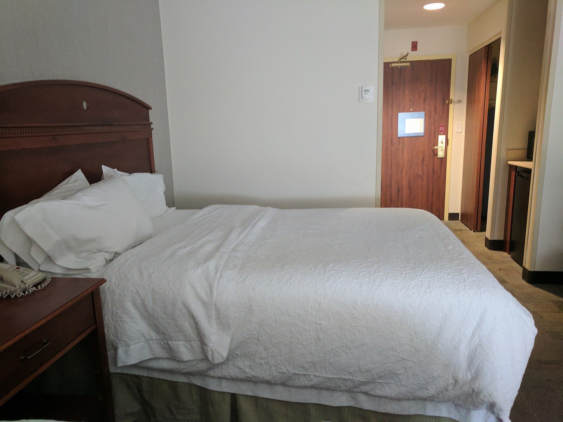 Room photograph — a bed made up as Executive 26 would be. Not a photograph of the unit itself.